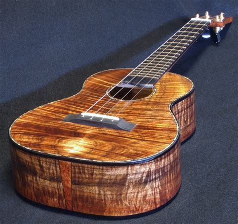 It has an ebony faced slotted headstock and the top and back are bound in ebony and beautiful abalone inlay around the top as well as the rosette. . Curly koa ukulele